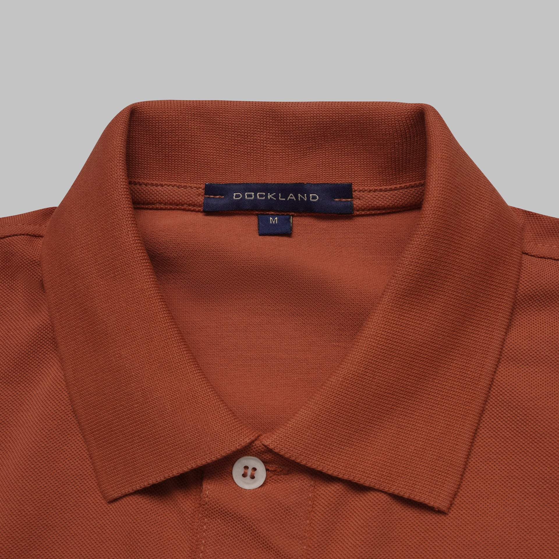 Shop classic fit pique copper polo shirt for men summer 2026 by Dockland - تسوق قميص بولو بيكيه رجالي كلاسيك نحاسي احمر صيفي 2026 من دوكلاند - ملابس رجالي كاجوال صيفي